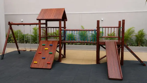 Estrutura de playground de madeira com escalada, escorregador, trama de cordas, balanço duplo